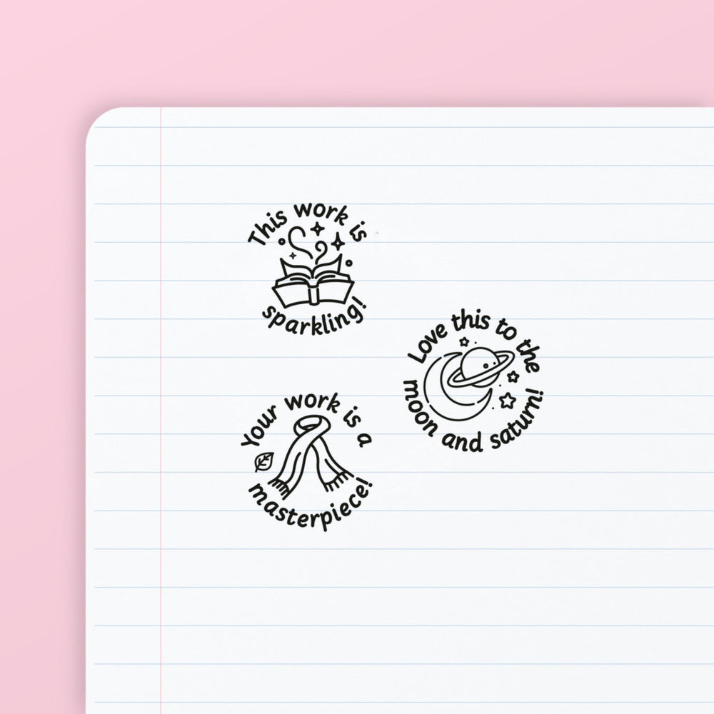 Pop Star Stamp Set 1 - the three teacher marking stamps in the set, stamped in black ink on lined paper: sparkling, moon and saturn, and masterpiece. My Teacher Says, handmade in Scotland.