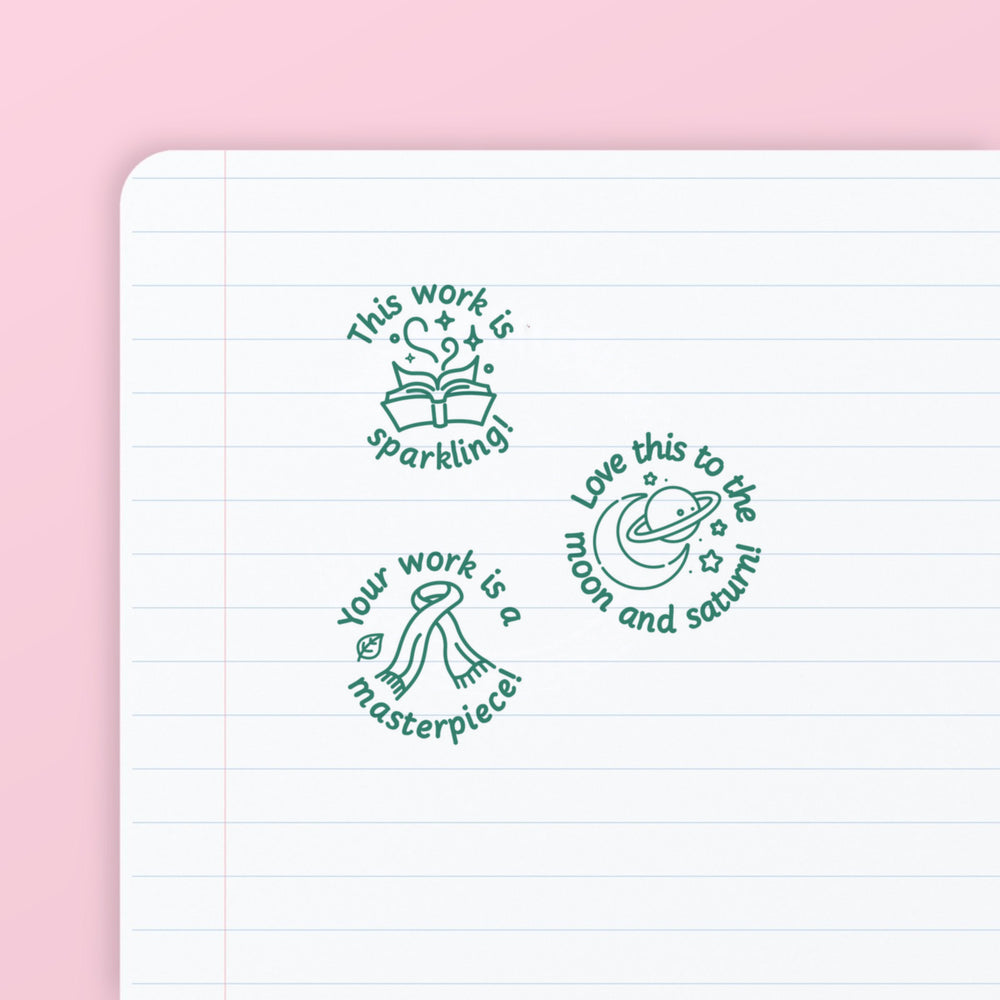 Pop Star Stamp Set 1 - the three teacher marking stamps in the set, stamped in green ink on lined paper: sparkling, moon and saturn, and masterpiece. My Teacher Says, handmade in Scotland.